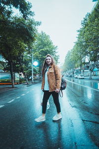 Full length portrait of teenage girl standing on road