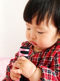 Close-up portrait of cute boy holding camera