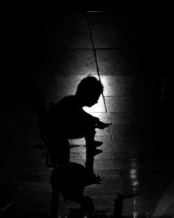 High angle view of silhouette woman sitting on floor