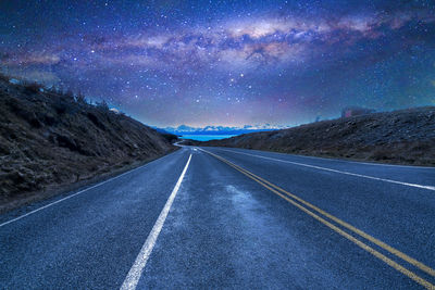 Road amidst landscape against sky at night