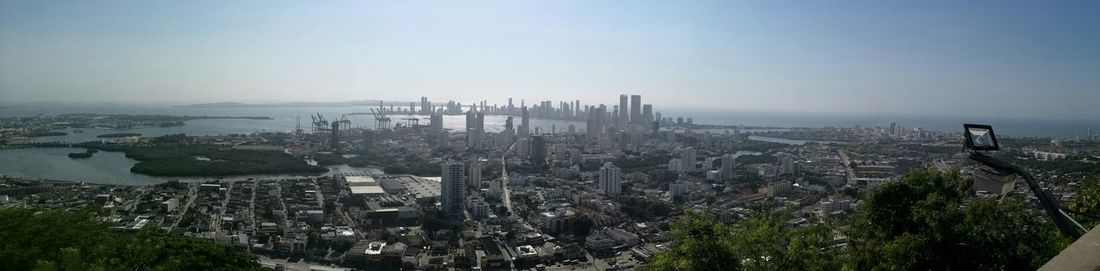 Panoramic view of cityscape by sea against sky