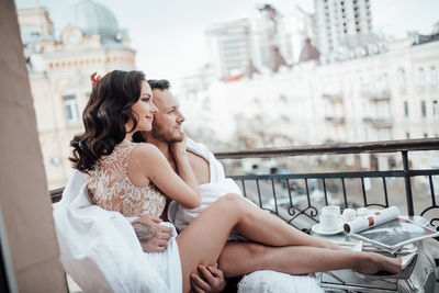 Young couple sitting on bridge in city