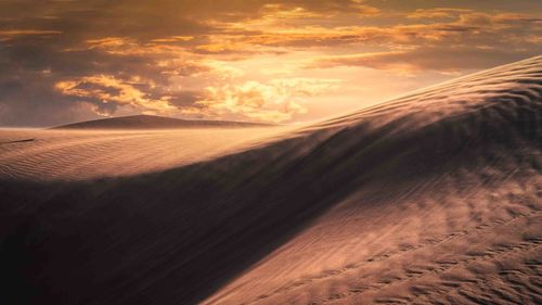 Scenic view of desert against sky during sunset