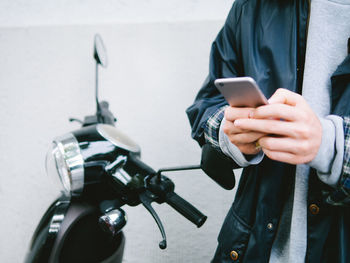 Midsection of man using mobile phone