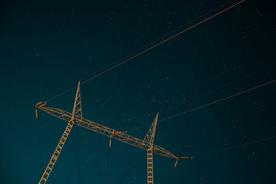 Low angle view of cranes against sky at night