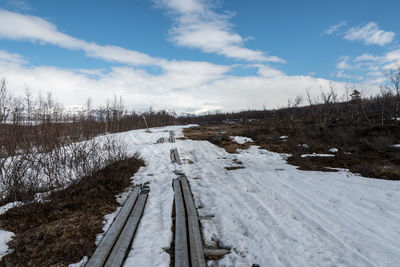 Snow covered landscape against sky