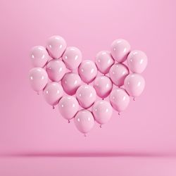 Close-up of red heart shape over pink background