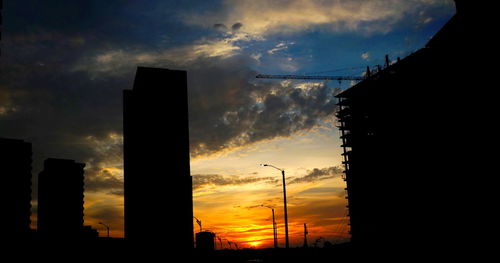 Silhouette of buildings against cloudy sky