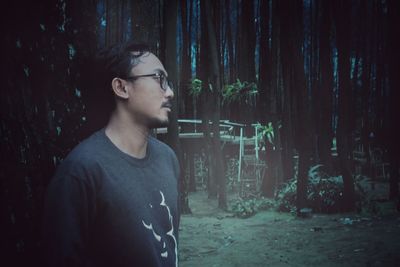Young man looking away in forest