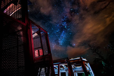 Low angle view of damaged trains against sky at night