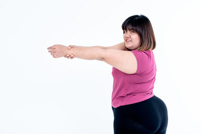 Woman standing against pink background