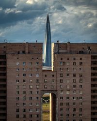 Low angle view of buildings against cloudy sky