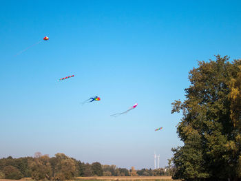 Low angle view of kite flying against clear blue sky