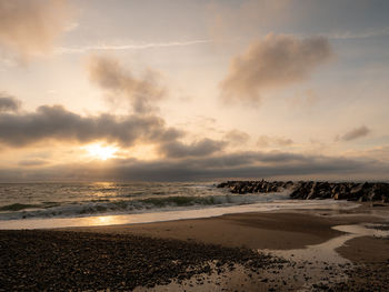 Scenic view of beach against sky during sunset