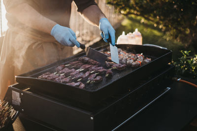 High angle view of person preparing food on barbecue grill