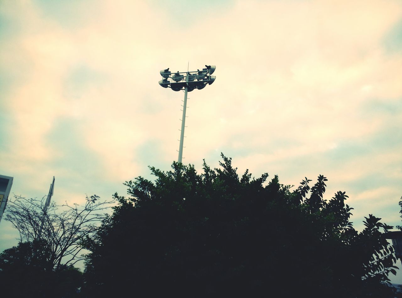 low angle view, sky, street light, tree, cloud - sky, lighting equipment, silhouette, cloudy, nature, growth, cloud, outdoors, pole, no people, day, dusk, beauty in nature, tranquility, plant, communication