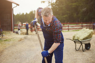 Farmer working with pitchfork in farm