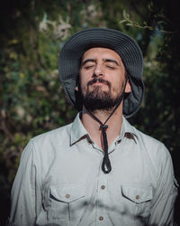 Portrait of young man wearing hat standing outdoors