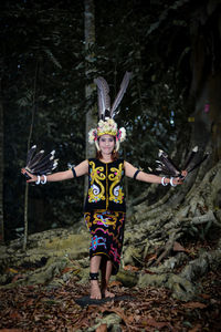 Rear view of woman standing against trees