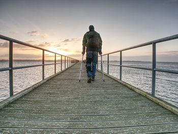 Rear view of man looking at sea against sky