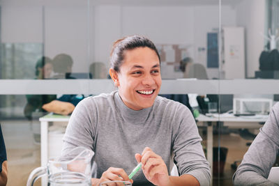 Portrait of a smiling young woman sitting on table