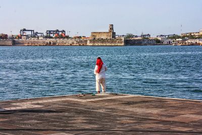 Man standing by sea against clear sky