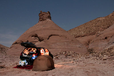 Man resting by tent at desert