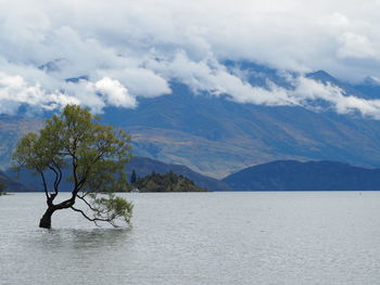 Scenic view of lake by mountains against sky