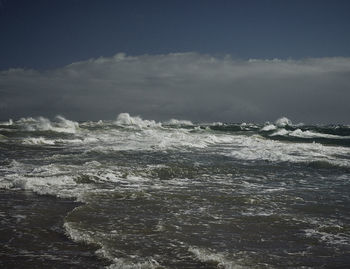 Scenic view of stormy sea against cloudy sky