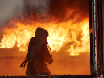 Silhouette of fire against sunset sky