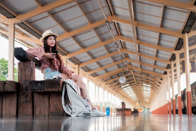 Low angle view of woman sitting on ceiling