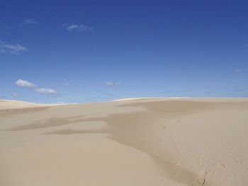 Scenic view of desert against blue sky