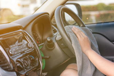 Cropped image of woman with textile sitting in car