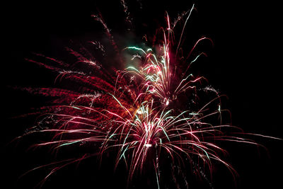 Low angle view of firework display at night