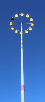 Low angle view of lighting equipment against blue sky