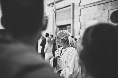 Woman holding metallic rod while walking in city