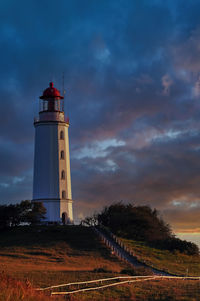 Low angle view of lighthouse by building against sky