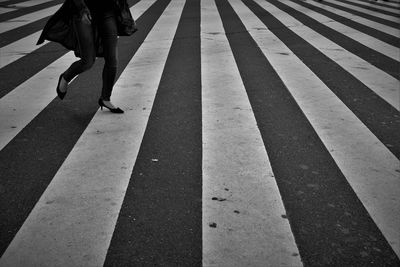 Low section of woman walking on road