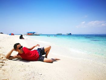 Full length of man relaxing on beach