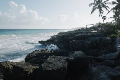 Rocks by sea against sky