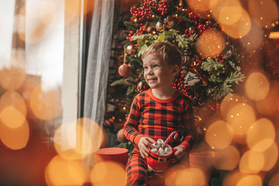 Portrait of girl playing with christmas tree