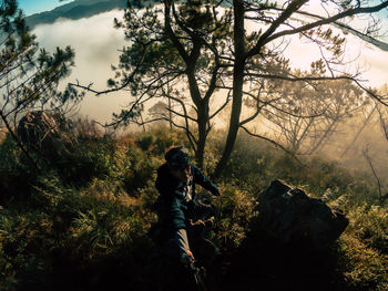 Man walking by trees in forest