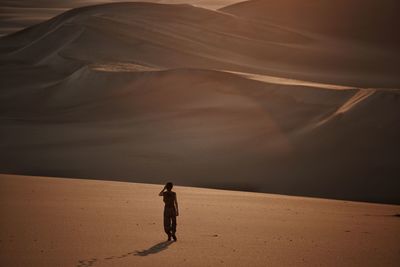 Full length of man standing on sand dune in desert