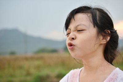 Close-up of cute girl puckering lips looking away