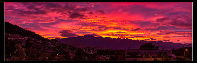 Scenic view of mountains against cloudy sky at sunset