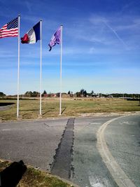 Flags waving on road against sky