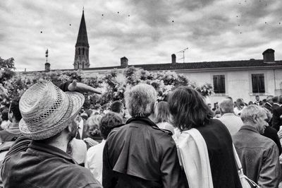 Rear view of people against sky in city