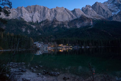 Scenic view of lake by mountains against sky