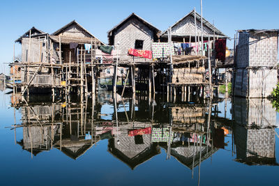 Reflection of built structure in water against clear sky