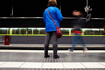 Rear view of woman standing on subway station